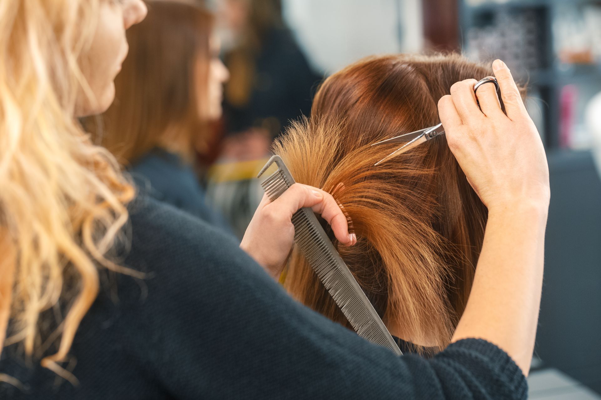 a woman having her hair cut by a stylist