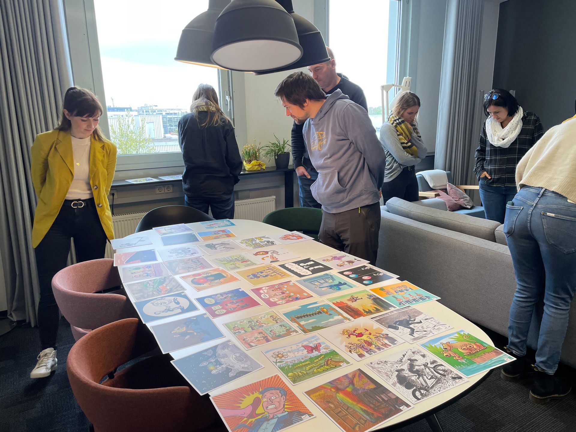 Seminar Teilnehmer betrachten bunte Bilder auf einem Tisch