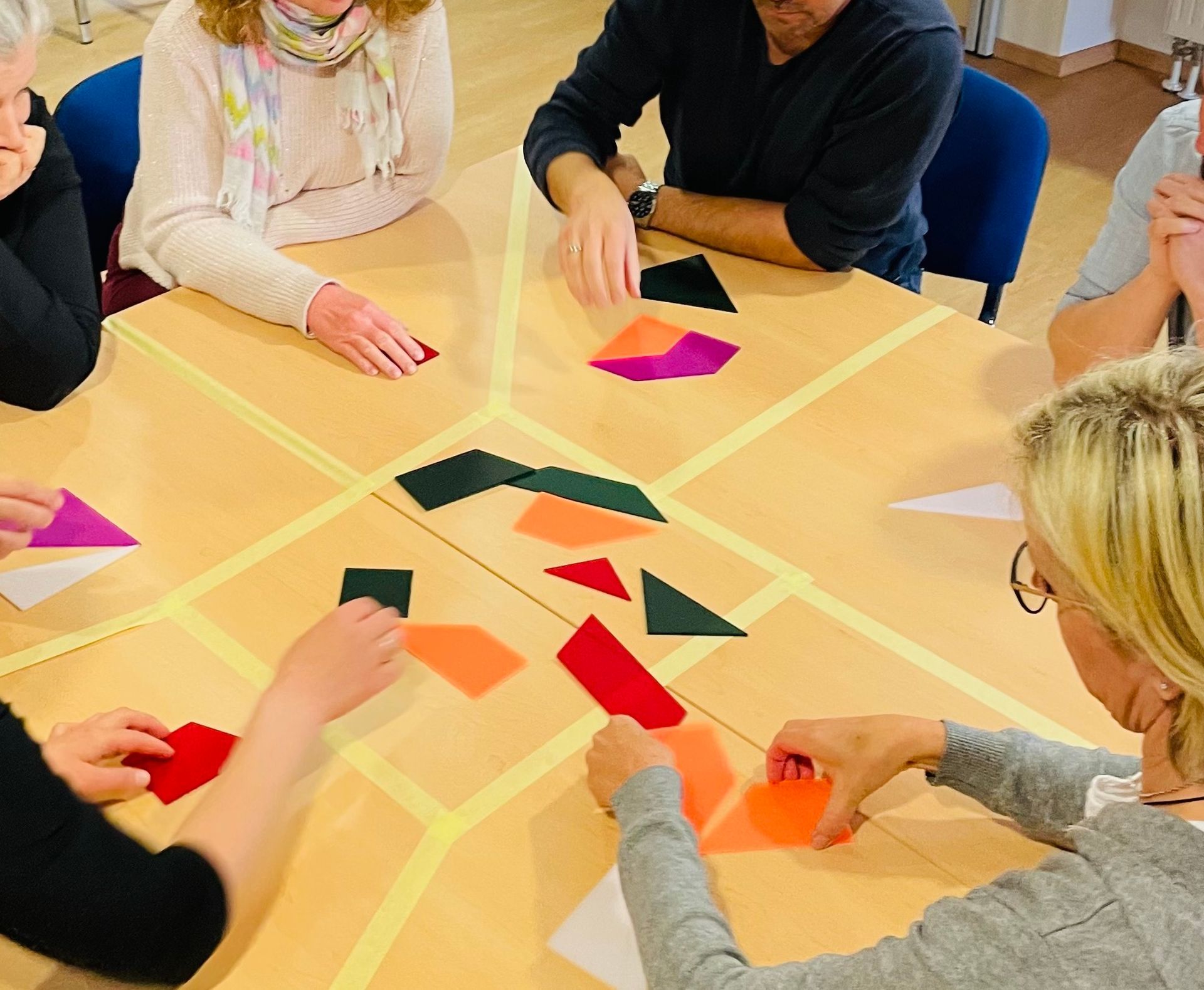 Teilnehmer legen Puzzleteile auf einen Tisch