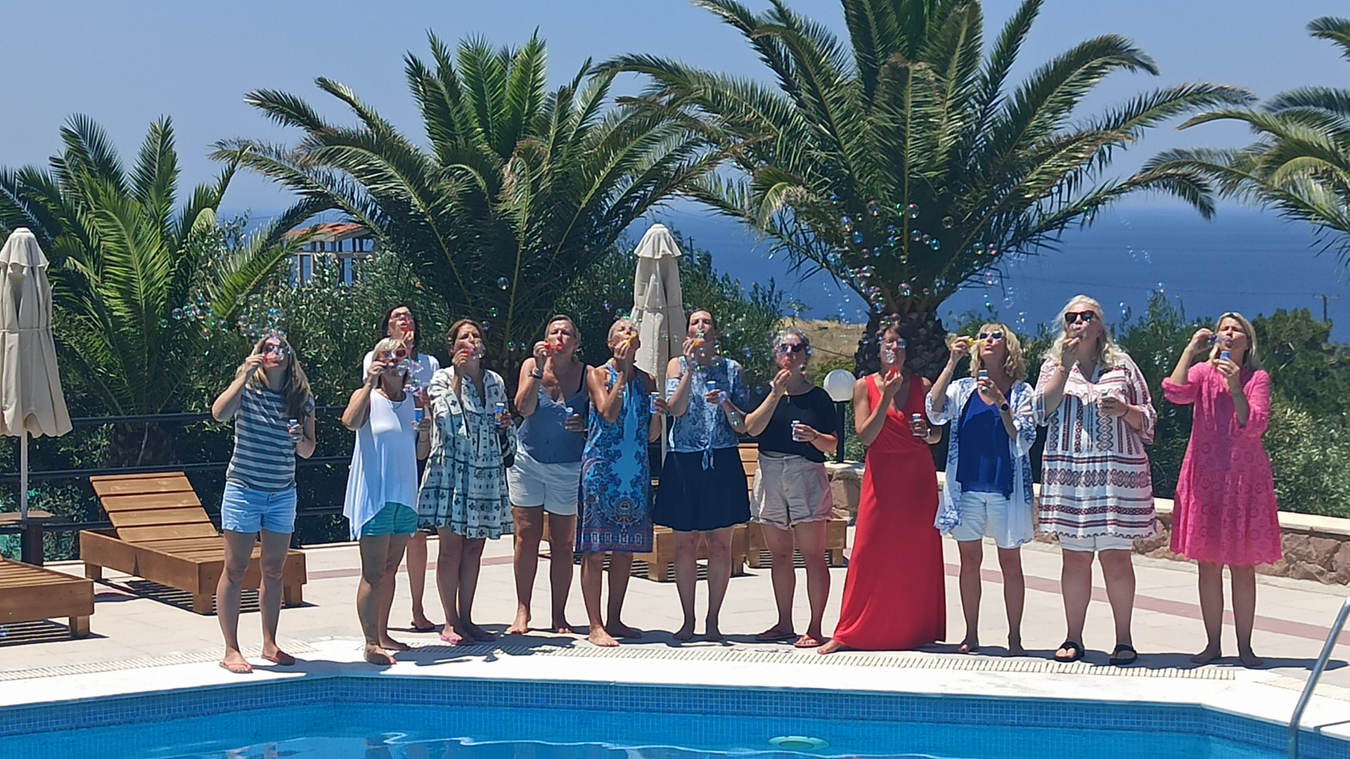 Frauen pusten Seifenblasen am Pool auf Lesbos
