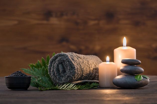 Wellness Arrangement mit Handtüchern, Kerzen und Hot Stones