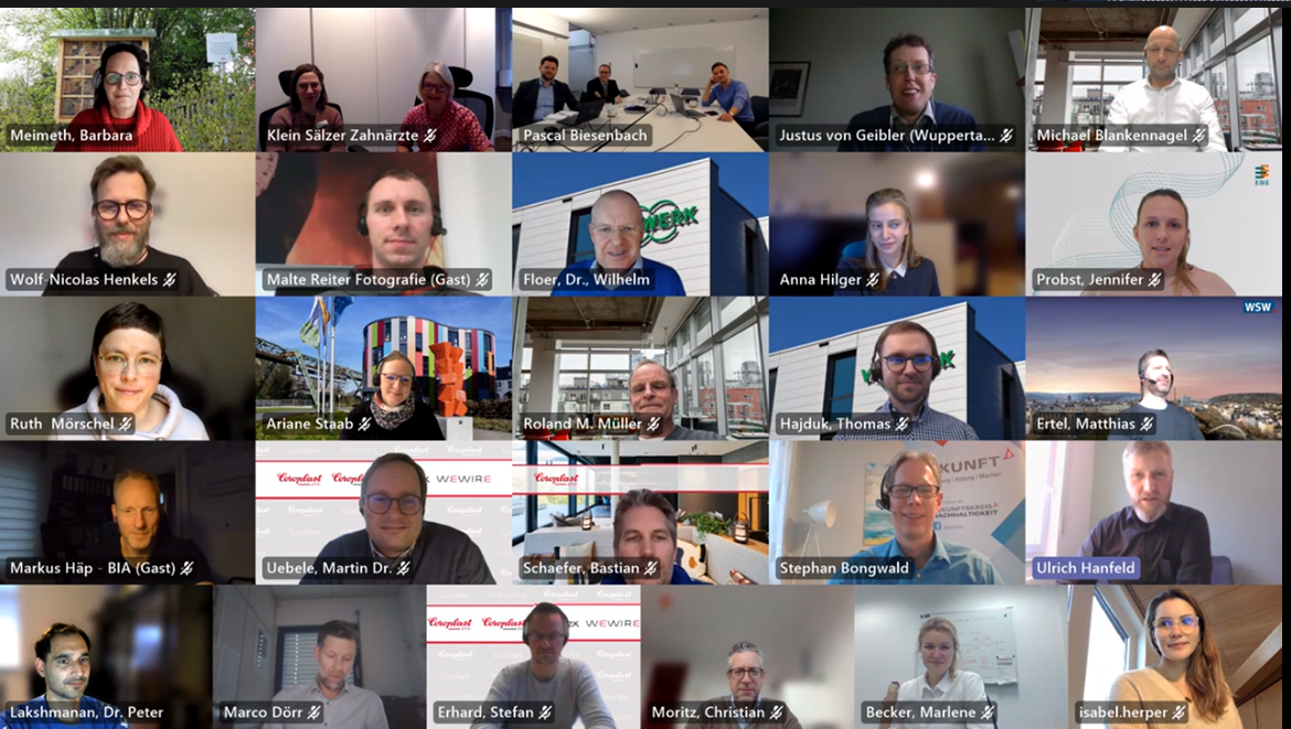 Ein virtuelles Treffen mit 29 Teilnehmern unterschiedlichen Geschlechtes, die in einem Raster angeordnet sind.