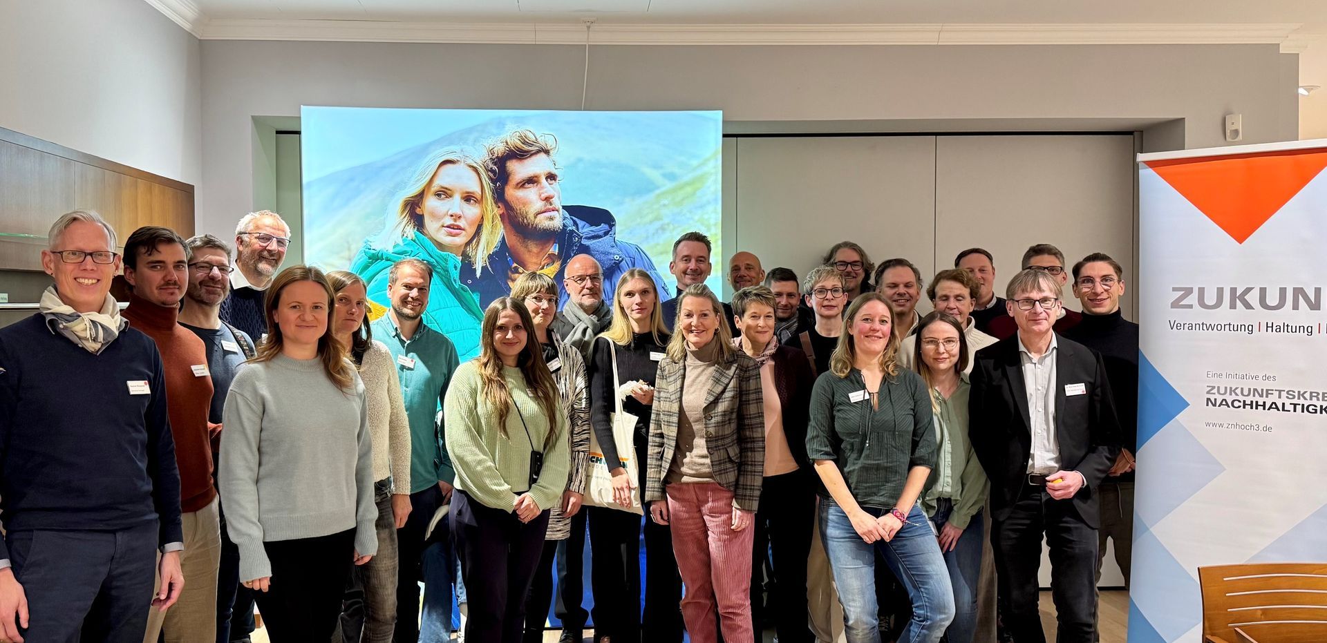 26 Personen beim Netzwerktreffen bei der Walbusch-Gruppe in Solingen. Sie stehen lächelnd in einem Konferenzraum.