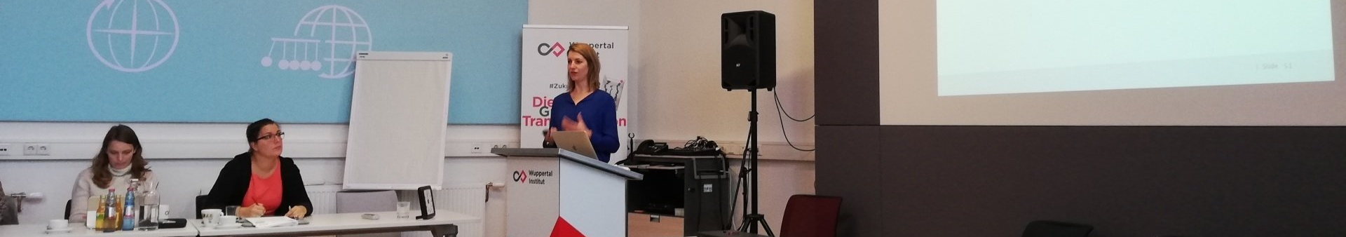 Eine Frau steht an einem Podium mit der Aufschrift