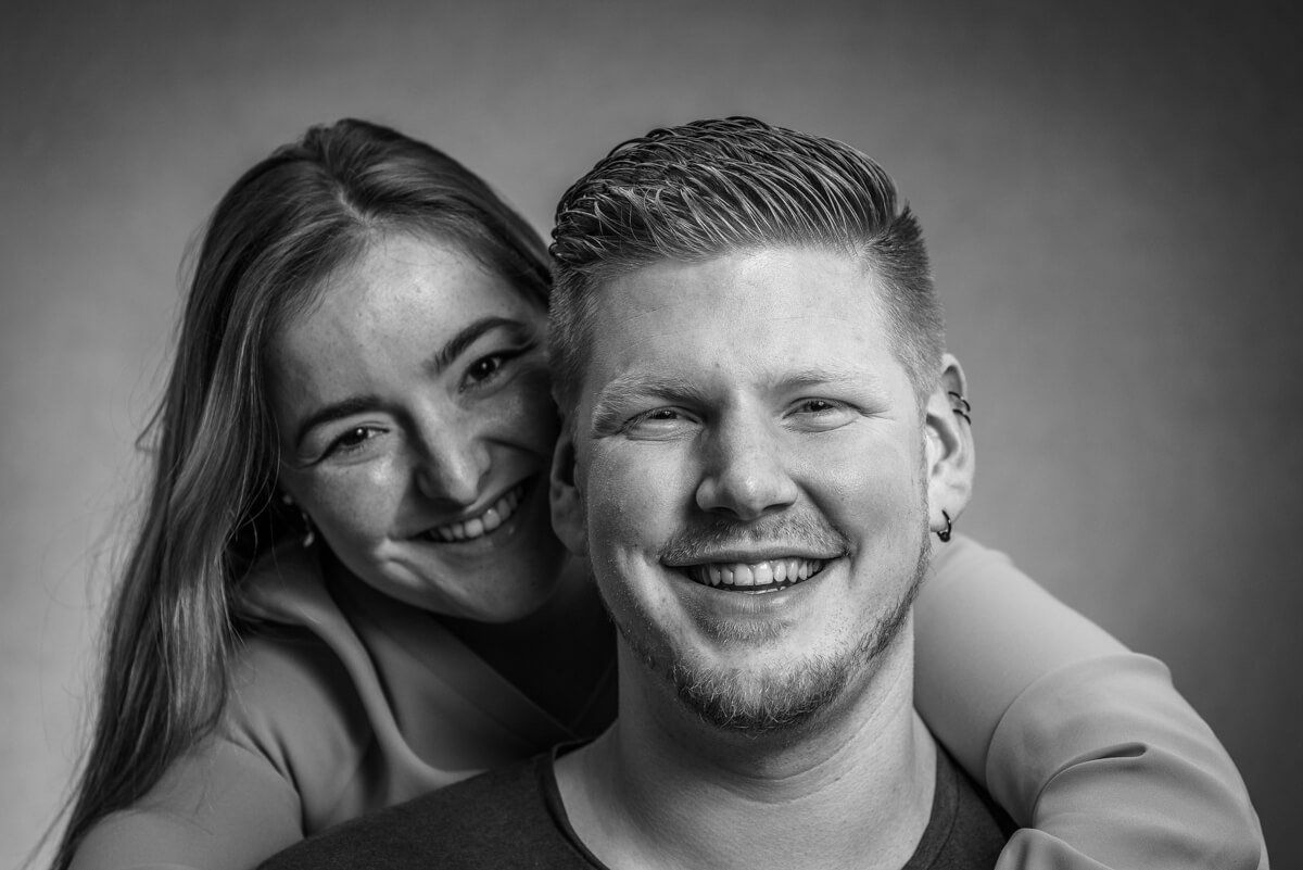 Portrait von einem jungen in die Kamera lächelnden Paar.