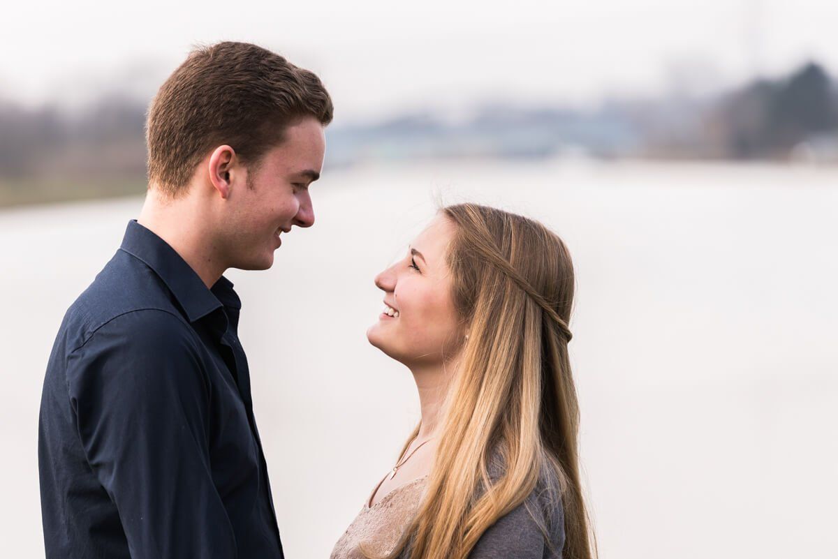 Portrait von einem jungen Paar am Dortmund-Ems-Kanal in Münster. Sie stehen sich gegenüber und lächeln sich an.