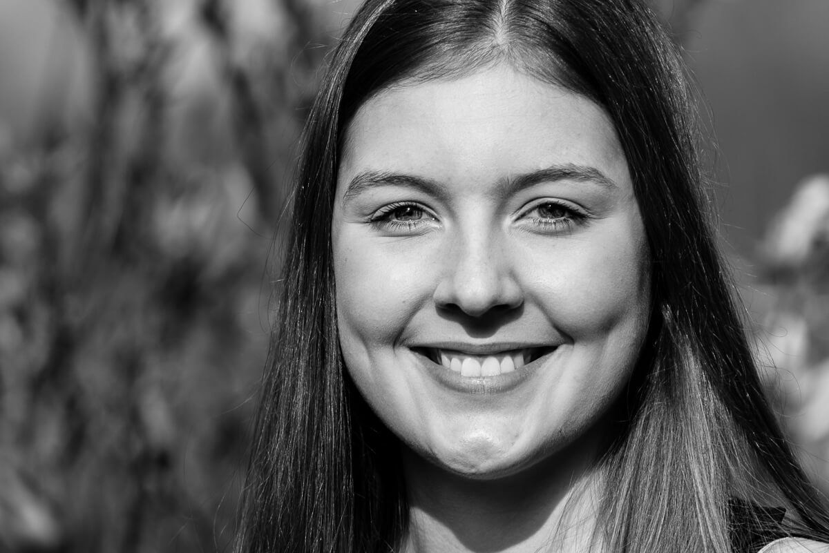 Ein Portrait einer jungen lächelnden Frau in schwarz-weiß.