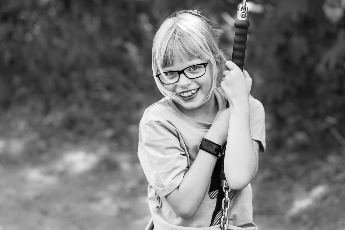 Portrait in schwarz-weiß von einem Mädchen, dass in die Kamera lächelt.