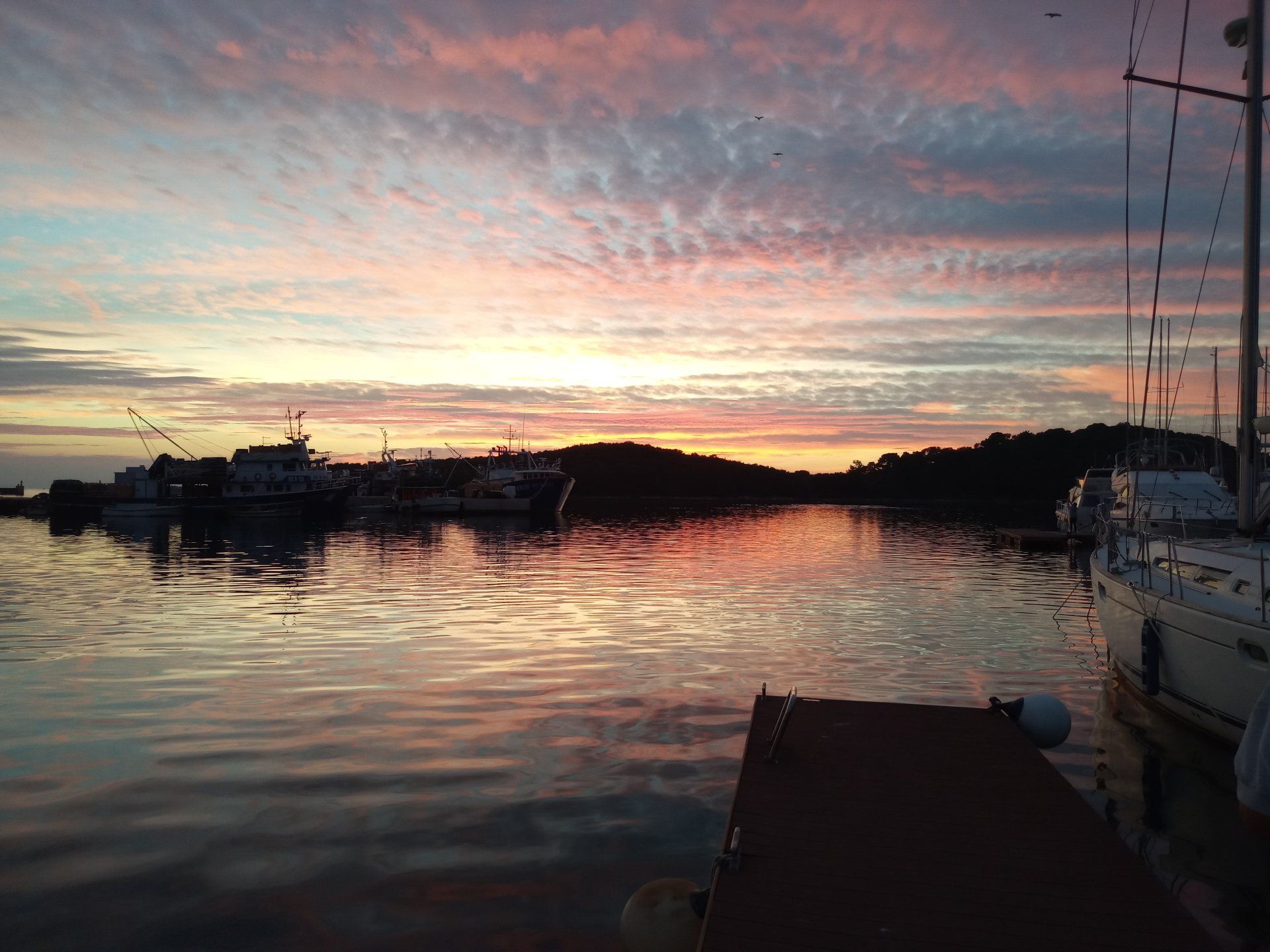 Wintersegeln in Kroatien: Romantischer Sonnenuntergang im Hafen.
