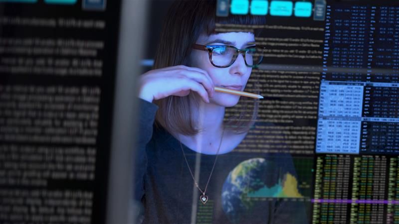 Software developer looking at computer screen with software code