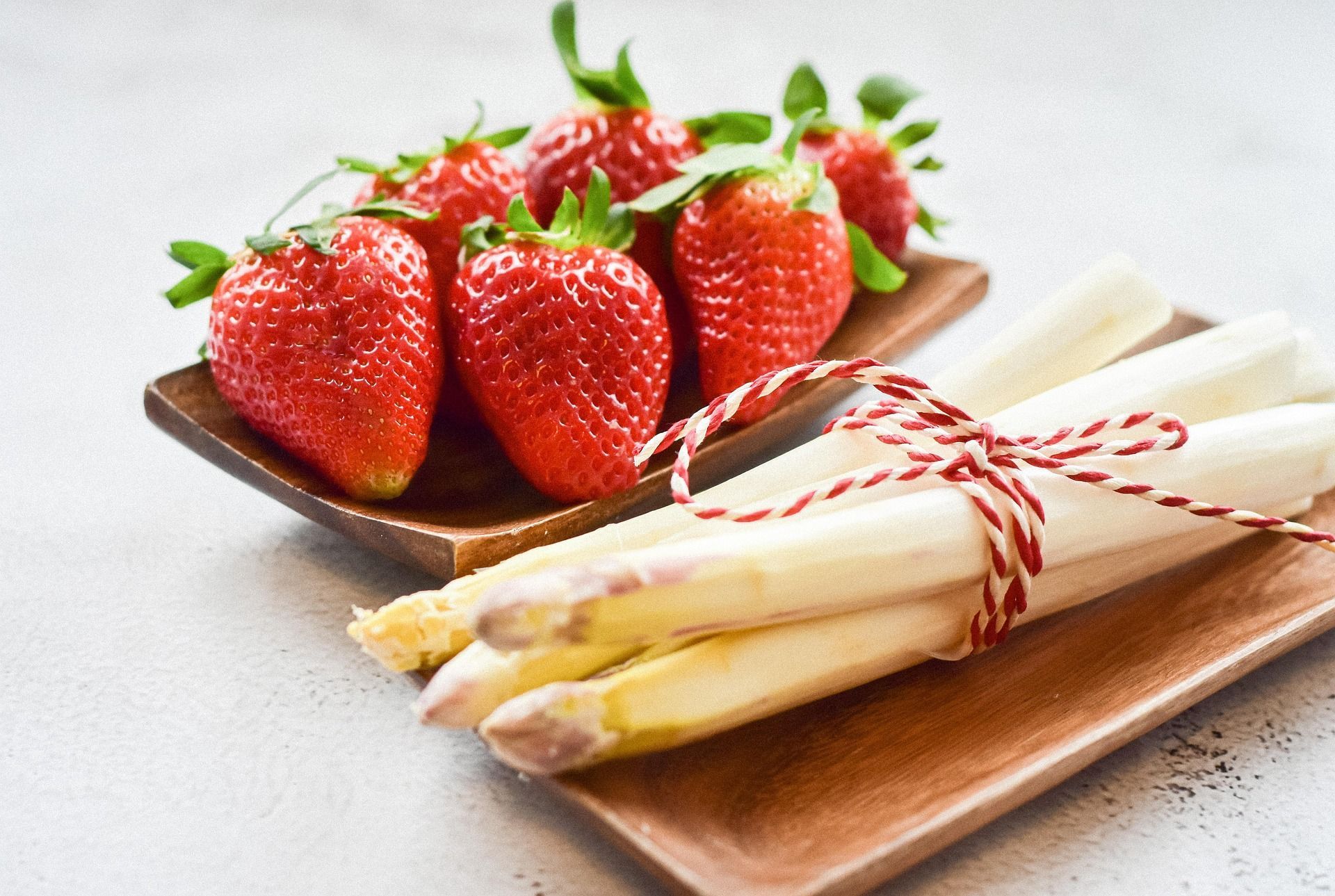 Frühlingshafte Kombination aus frischen Erdbeeren und weißem Spargel