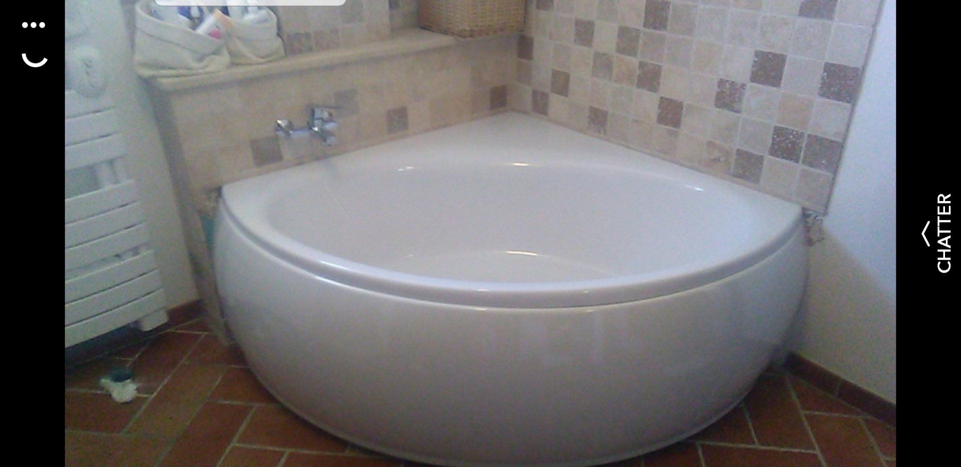 baignoire ronde d'angle et salle de bain avec un petit carrelage brun et beige