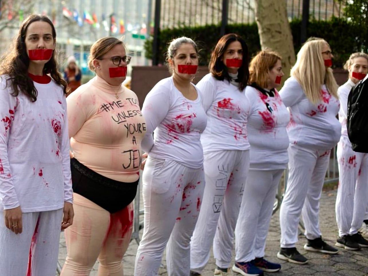 New York devant le siège de l’ONU, des femmes portant des habits ensanglantés pour dénoncer le silence vis à vis femmes israéliennes victimes de viols.