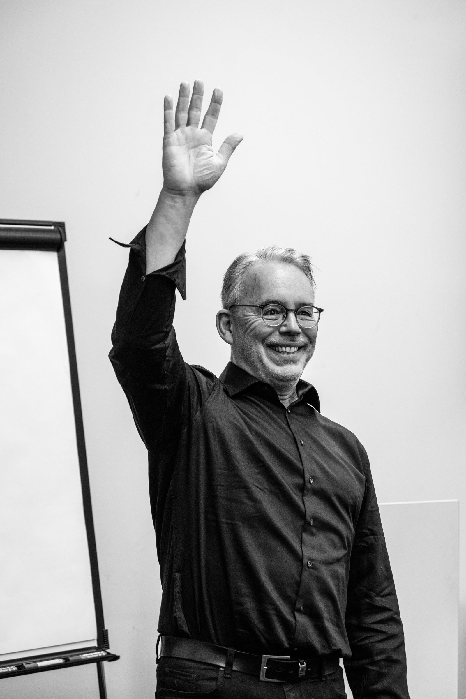 Ein Workshop-Leiter hebt den Arm. Eventfotografie aus Hamburg von Fotograf Kay Winter / WINTERPOL