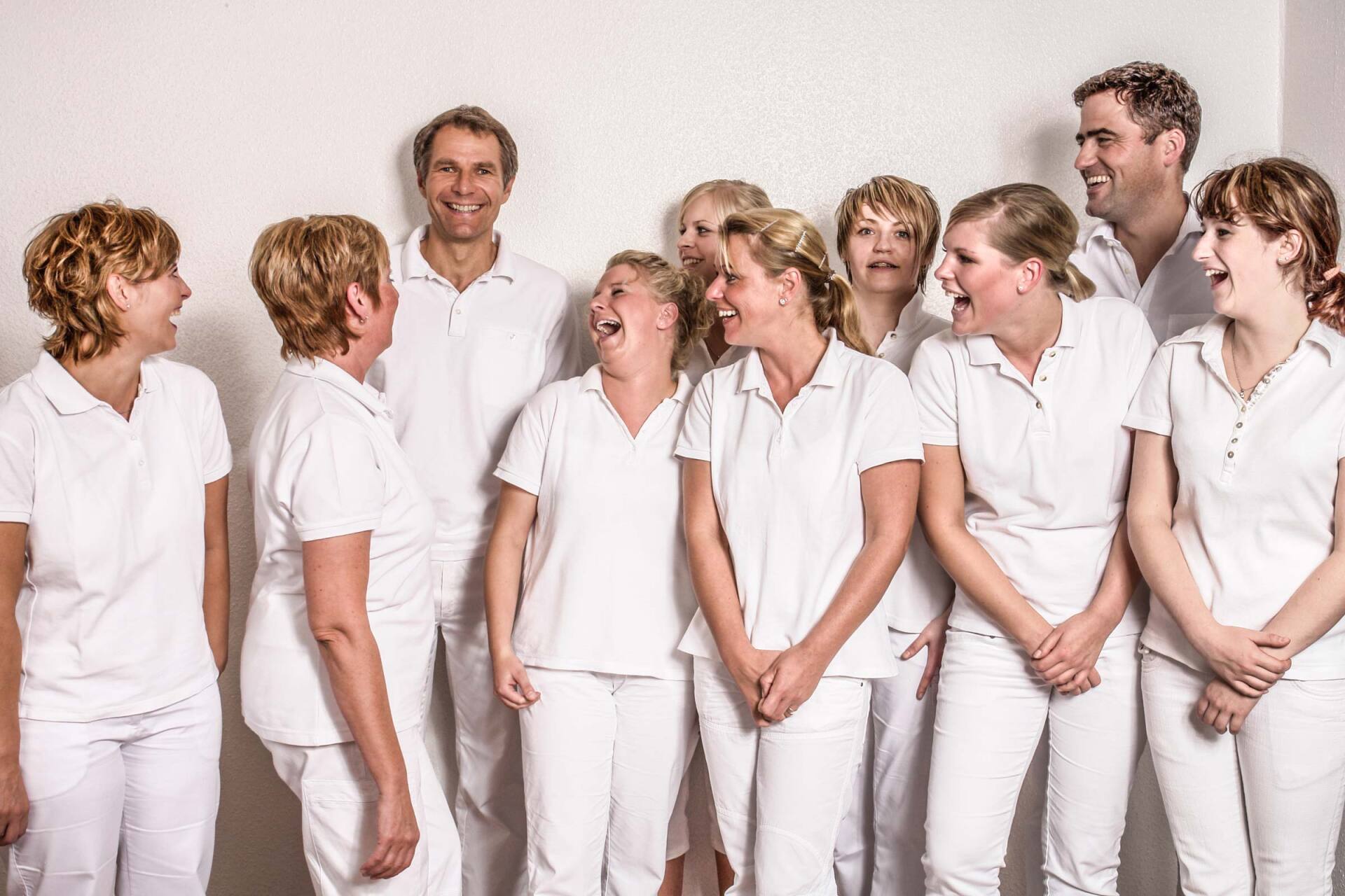Das Team eines Arztes lacht über den Scherz ihres Chefs, Businessfotografie aus Hamburg von Kay Winter / WINTERPOL