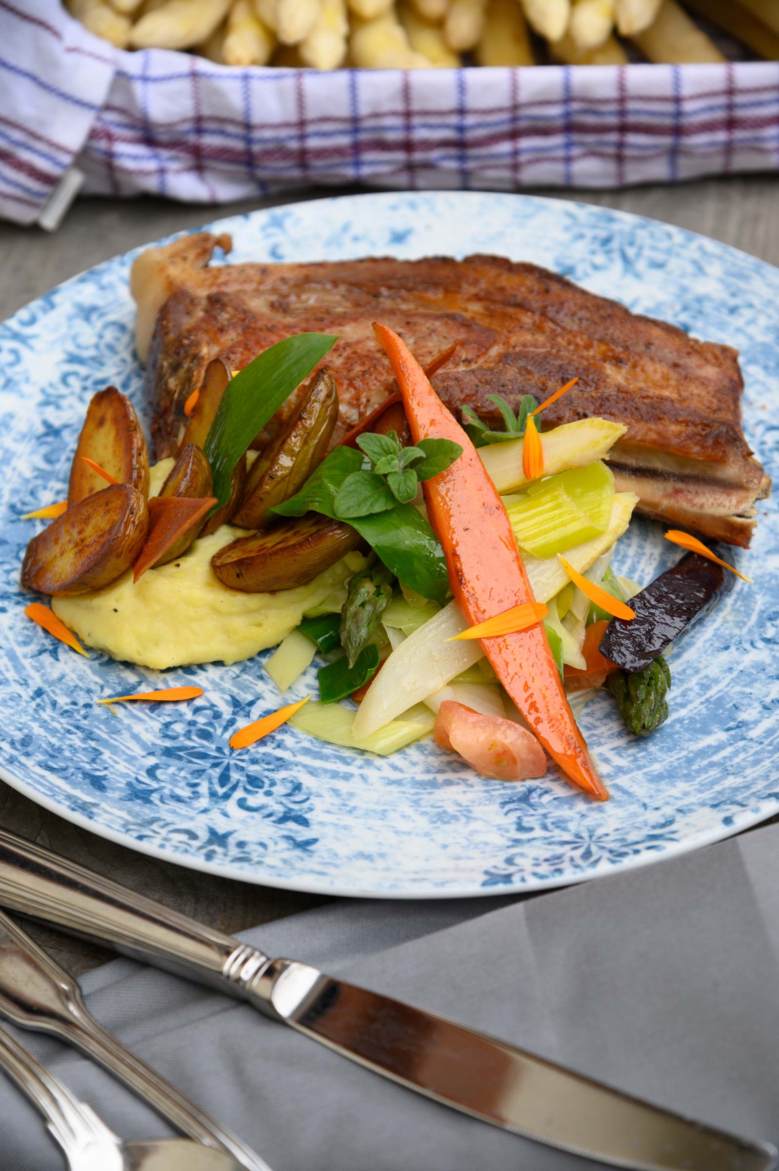 Food-Fotografie von WINTERPOL Hamburg Schweinekotelett, Kartoffeln und Gemüse auf einem blauen Teller, Foodfotografie aus Hamburg von Fotograf Kay Winter / WINTERPOL