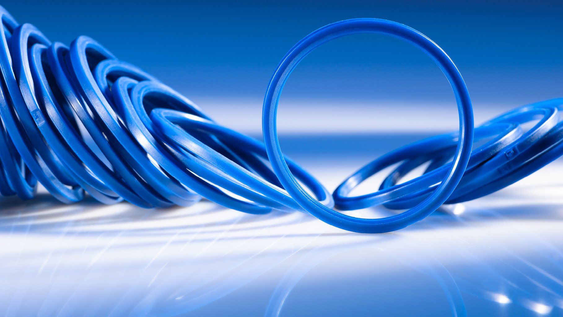 Produktfotografie von WINTERPOL Hamburg Blaue Dichtungsringe auf einem spiegelnden Untergrund, Werbefotografie aus Hamburg von Fotograf Kay Winter / WINTERPOL