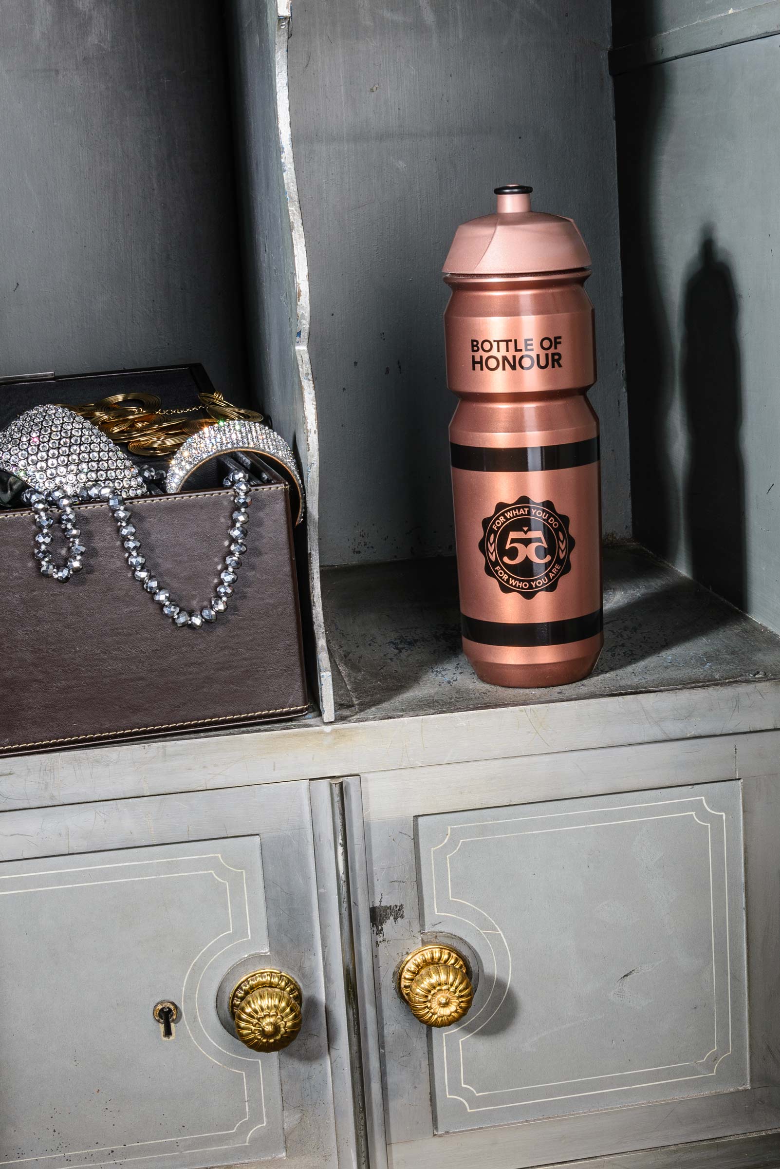 Eine Trinkflasche und Schmuck in einem alten Safe, Werbefotografie aus Hamburg von Fotograf Kay Winter / WINTERPOL