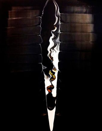 Dunkle, nächtliche Szene mit einem großen fliegenden Insekt. Das Insekt hat einen raupenförmigen Körper und seitlich ausgebreitete, zart weißlich-silberne Flügel, die in der Nacht schimmern.