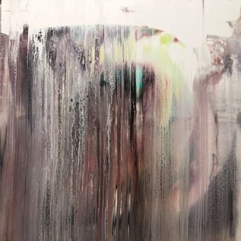 Nächtliche Situation, Regen, angelaufene Fensterscheibe, durch die man nur unscharf die Lichter von vorbeifahrenden Fahrzeugen, Laternen und Geschäften erkennen kann.