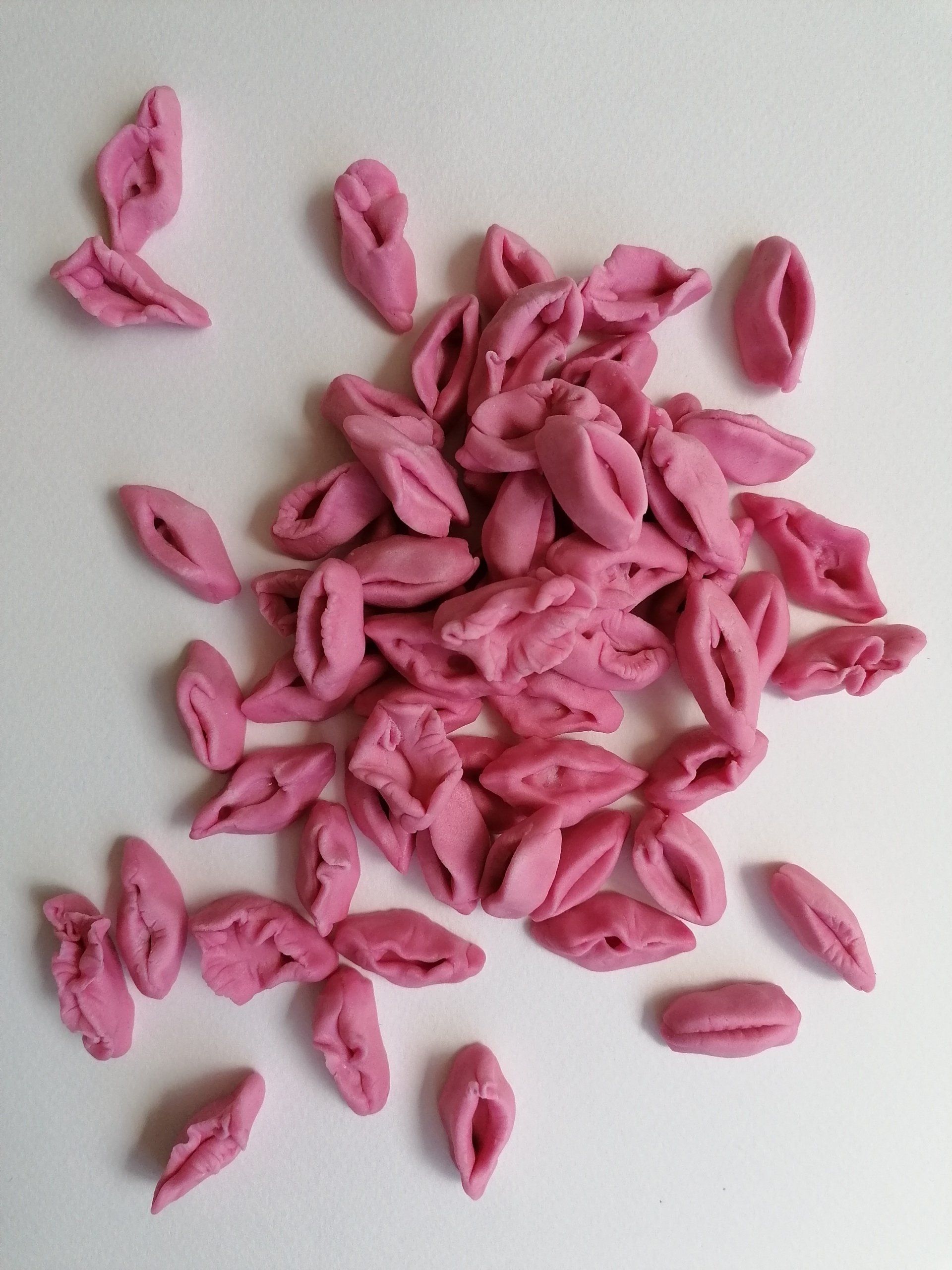 Foto eines Haufens von aus pinkem Kaugummi geformten Vulven