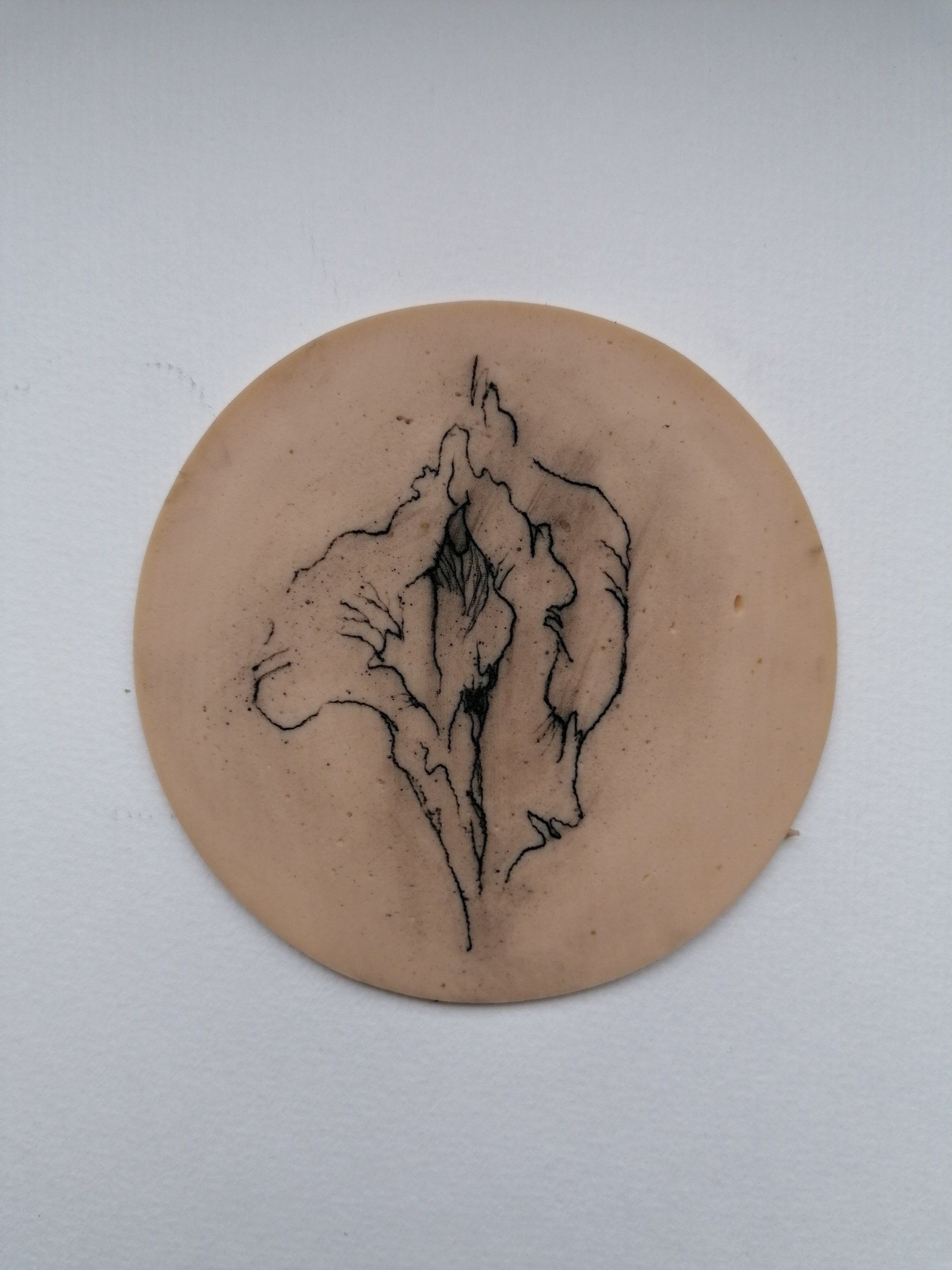 mit dem Motiv einer Vulva tätowierte Wurstscheibe