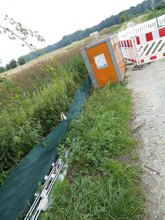Dort wo ein Schutzzaun wichtig wäre, fehlt er. Baugrube auf Feldweg und schlampig aufgebauter Amphibienzaun.