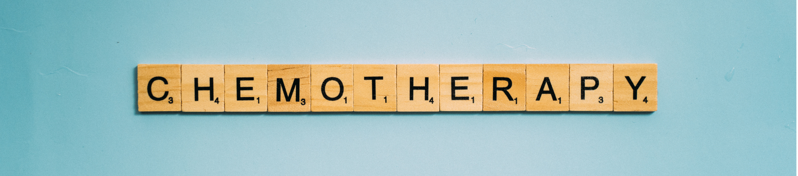Image shows wooden scrabble tiles spelling out the work Chemotherapy with a blue background