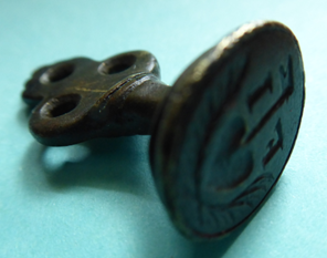 Nahaufnahme eines historischen Petschafts aus Bronze, ein kleiner verzierter Stempel zum Versiegeln