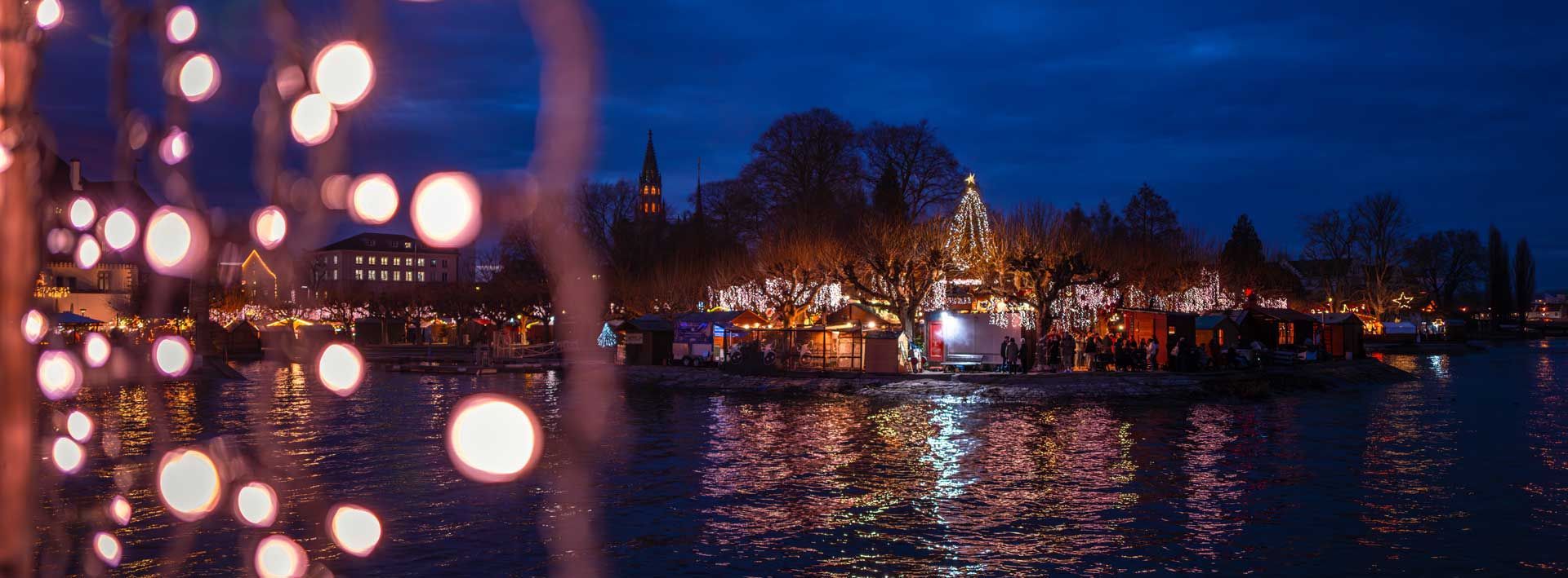 Blick auf den Weihnachtsmarkt Konstanz Abendliche Stimmung mit Weihnachtsbeleuchtung und Bodenseekulisse