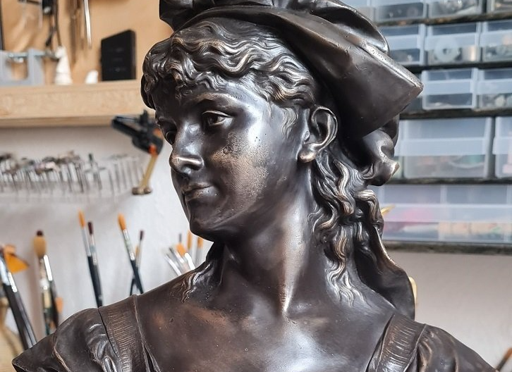 Die Büste wurde bestrahlt, kleine Kratzer und Einschläge beseitigt und große Fehlstellen in Schweißverfahren restauriert. Verformungen im Sockel wurden restauriert. Als Oberflächenfinish erhält die Büste eine dunkle Bronze Patina und wurde mit Spezialwachs versiegelt.