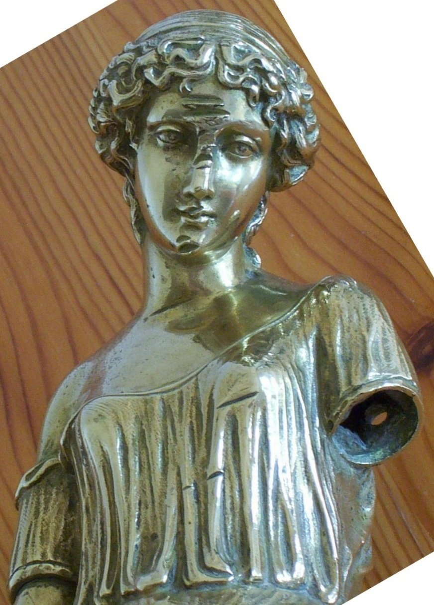 Ausschnitt von Messingfigur vor Restauration. Einschlagschäden am Messing. Ein Arm nicht vorhanden. Details fehlen.