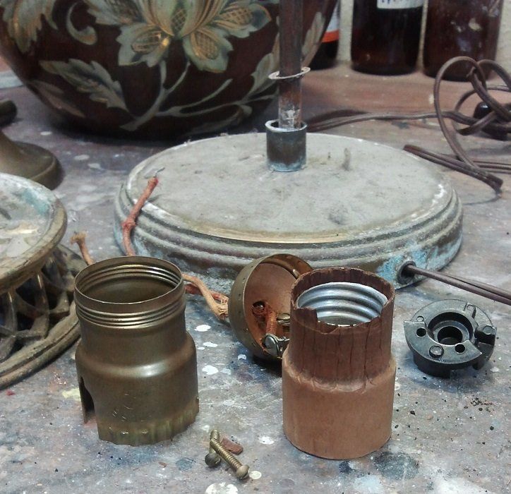 Lampe während der Reparatur. In Einzelteile zerlegt. Sehr schlechter Zustand der Einzelteile der Lame. Starke schäden am Zinnsockel. Restauration Lampe. Restauration Zinnsockel.