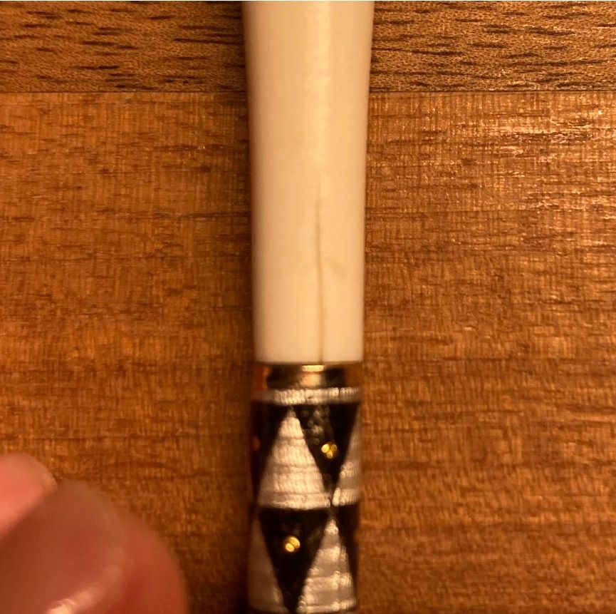 Restaurierung von einer Zigarettenspitz aus Elfenbein, Wiener Werkstätte. Mit 2 cm Riss. Restaurierung von Rissen und Fehlstellen in Elfenbein. Riss mittels Spezialkleber füllen/stabilisieren. Riss mit Elfenbeinfarbiger Modelliermasse ergänzen, Schleifen und Polieren.