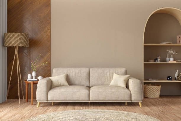 A beige couch in front of a wall, represents a minimalist approach to office paint colors.