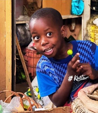 Land & Leute Ein dominikanisches Kind am Markt lächelt in die Kamera