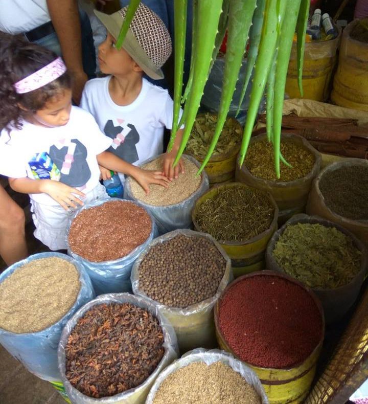 Marktbesuch Kleine Kinder mit Gewürzen auf dem Markt