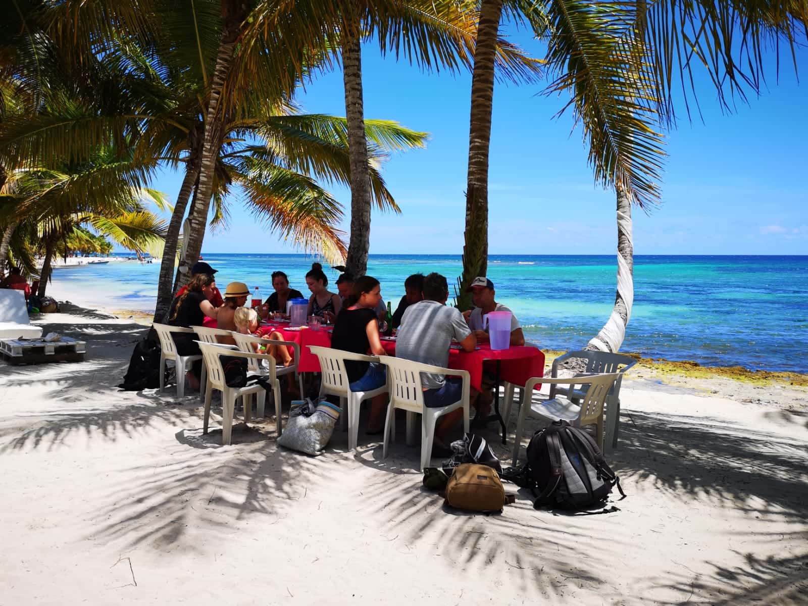 Gruppe sitzt beim Mittagessen am Strand