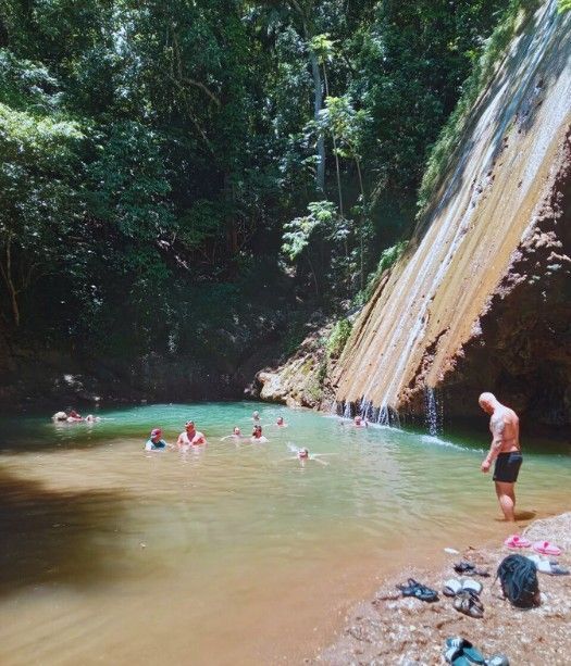 Wasserfall Samaná Gruppe badet im Becken vor einem Wasserfall