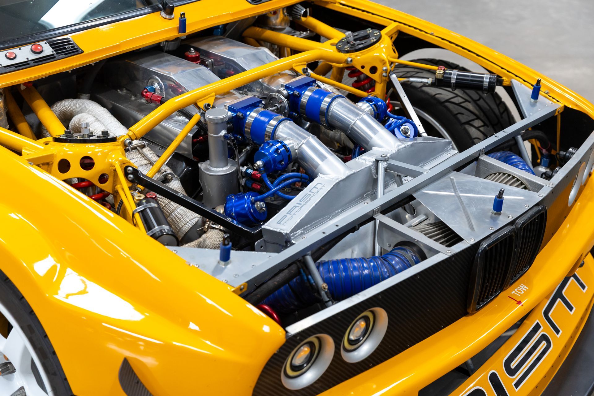 BMW E30 twin-turbo race car in burnt yellow