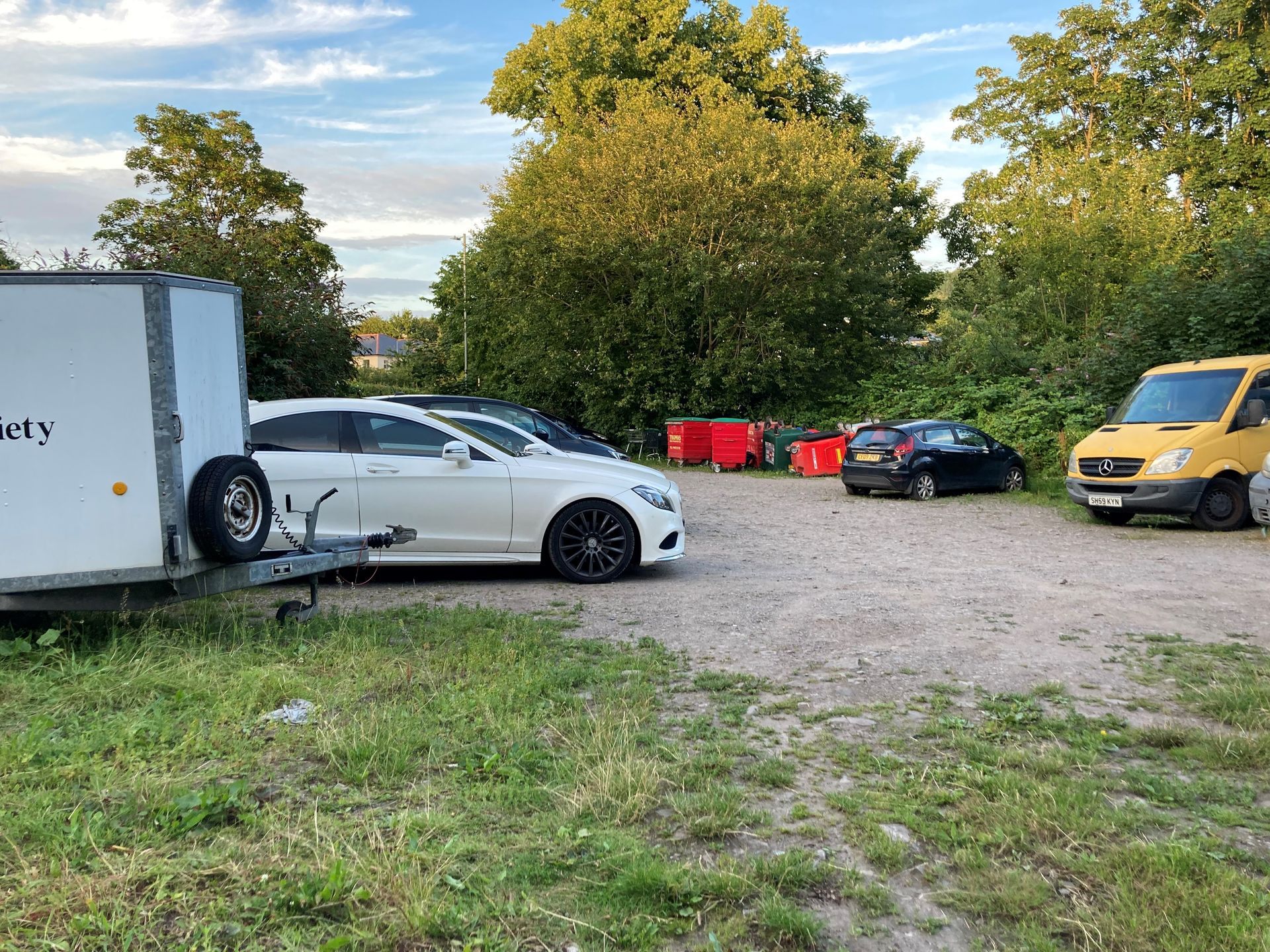 Scrub land with wheely bins and cars parked Land at the rear of Gunter Mansion