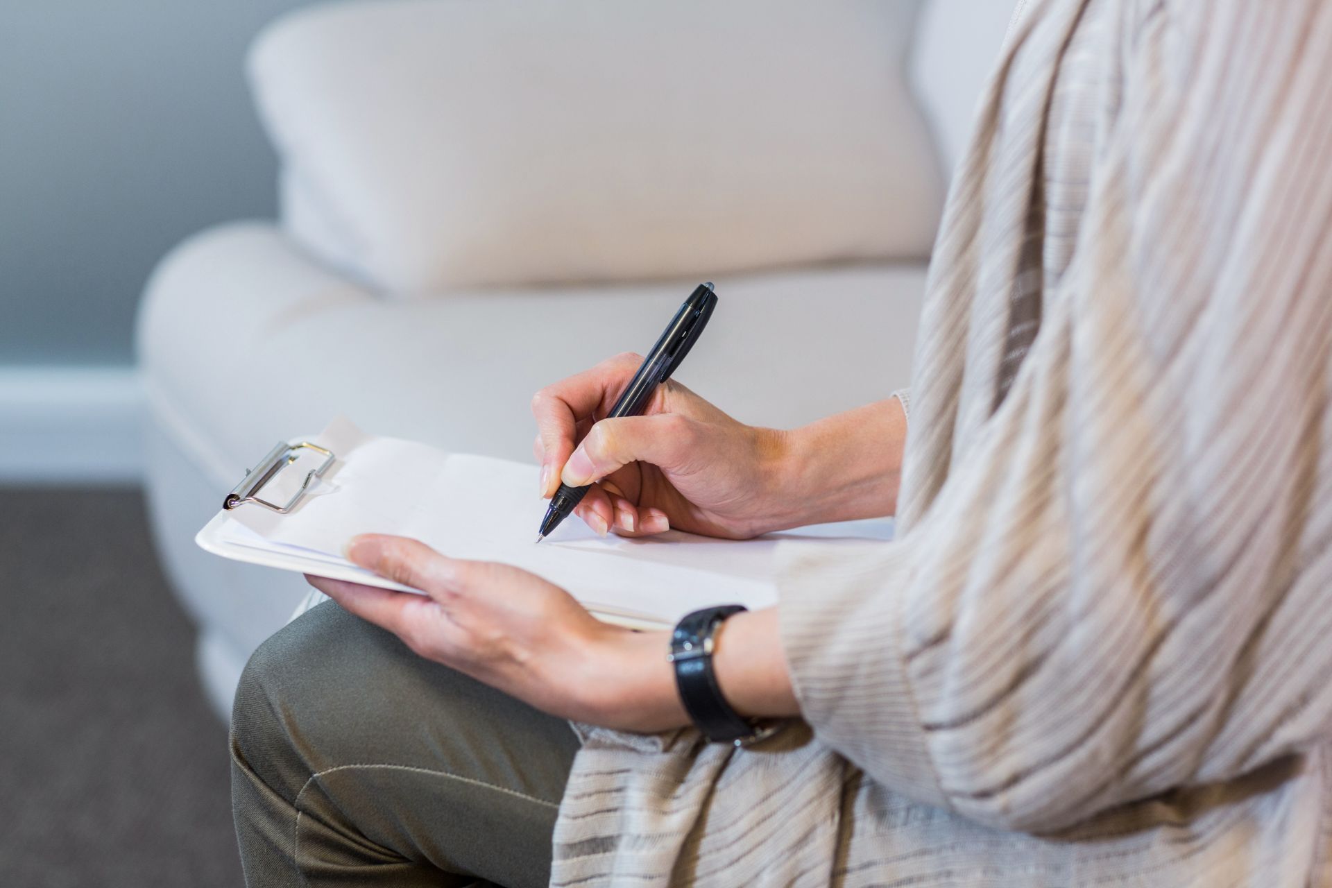 woman writing on clipboard