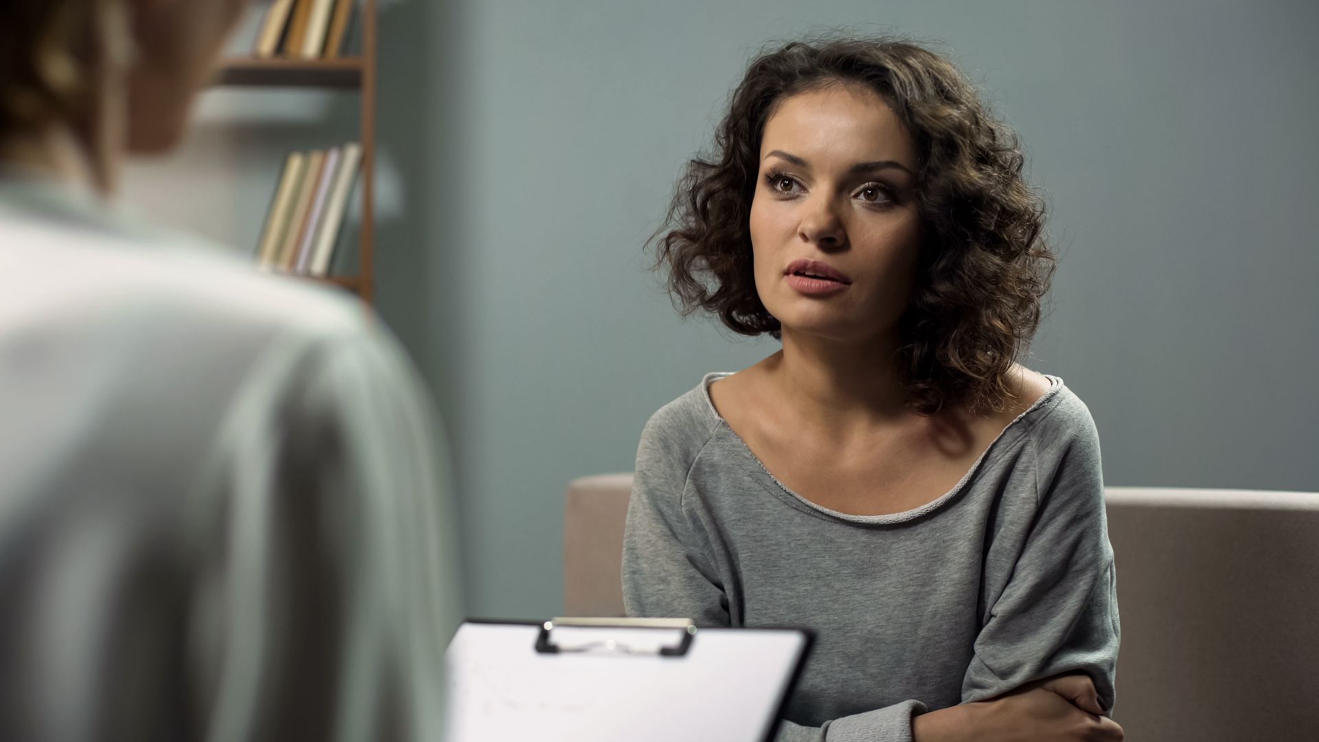 woman speaking to woman writing on clipboard