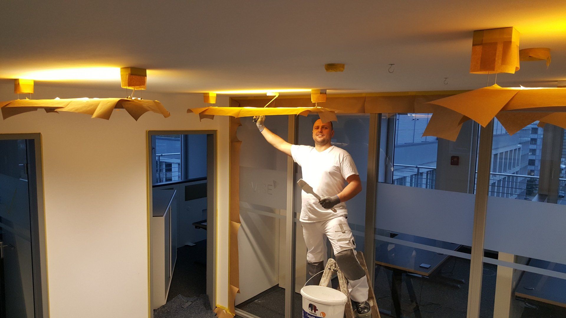 Dirk Szymanski Malergeselle bei der Arbeit. Eine Decke in einem Bürogebäude wird gestrichen