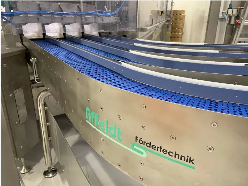Mehrbahniges 4-Bahn-Kurvenband zur platzsparenden Richtungsänderung mehrerer Produktlinien – Affeldt Fördertechnik