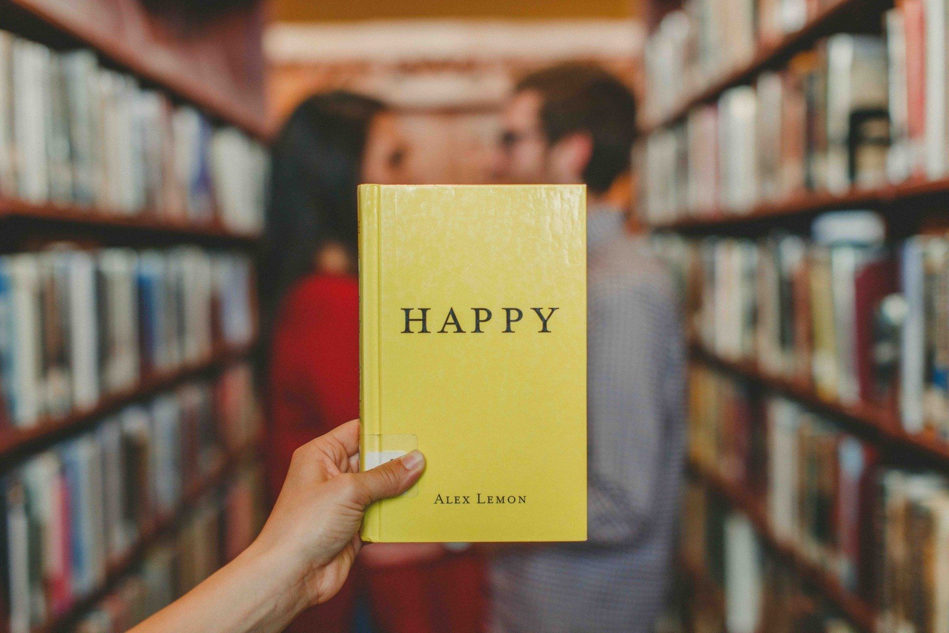 Livre-bonheur-happy-couple-heureux-love-amour-bibliothèque-main-pouce-poignet-rayons-profil-couverture-jaune-titre-lettres philothérapie-philotherapie-cabinet-consultation