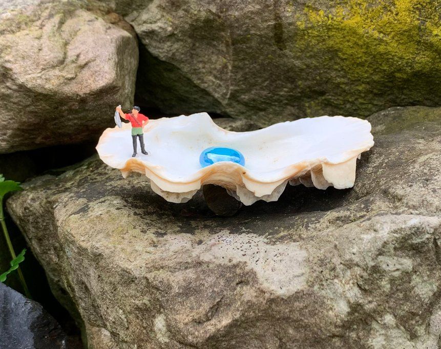 Muschel mit Glastropfen und H0-Figur mit dickem Fisch in der Hand