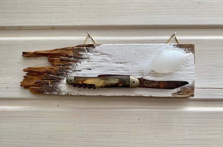 altes messer und plastikfisch auf altholz