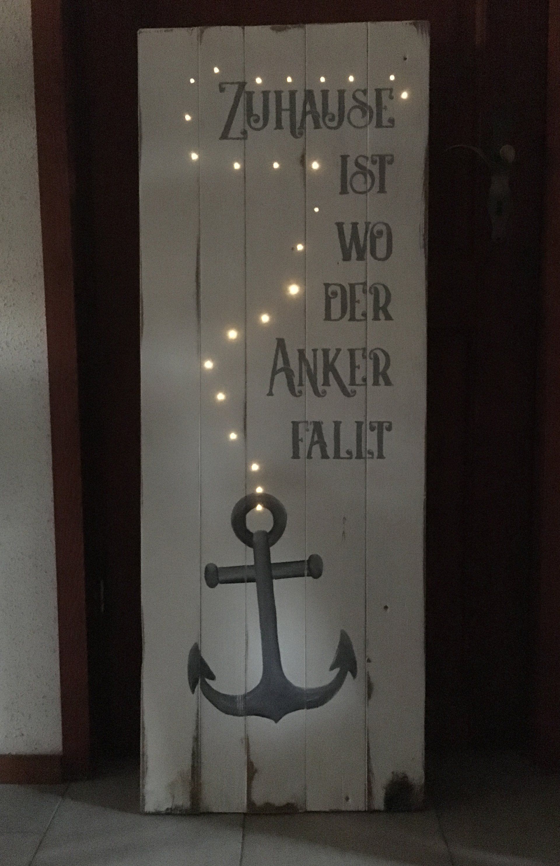 Weißes Palettenbild mit gemaltem Anker, Kette aus Lichterkette