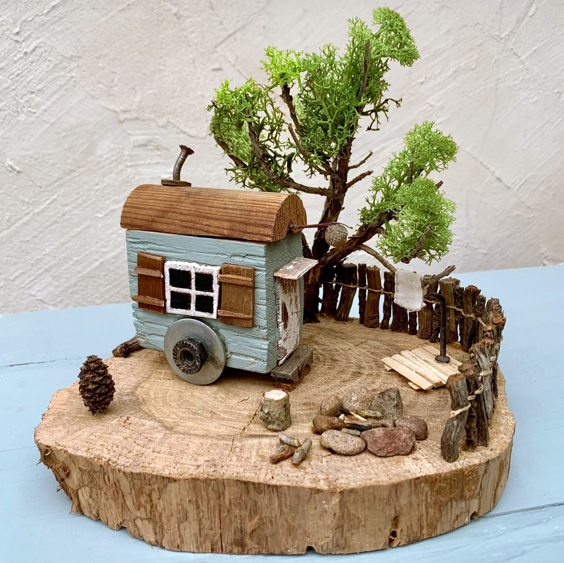 Bauwagenidylle, Miniatur Bauwagen aus Holz auf Baumscheibe, Baum mit Echtmoos, Aussendusche und Feuerstelle